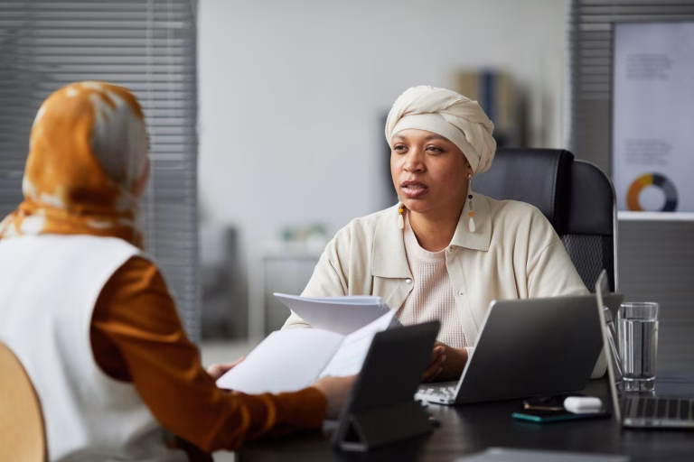 Businesswoman having a conversation in an office setting with colleague.